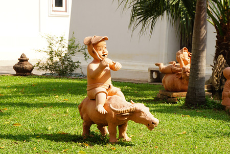 Clay statue in kid and buffalo shape garden decorative itemの写真素材