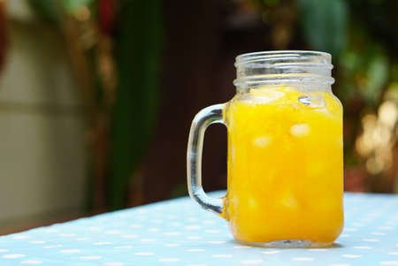 Orange juice in the glass jar with nature backgroundの写真素材