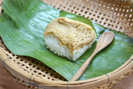 traditional Thai sweetmeat made from sweet sticky rice with egg custard in banana leaves packageの写真素材