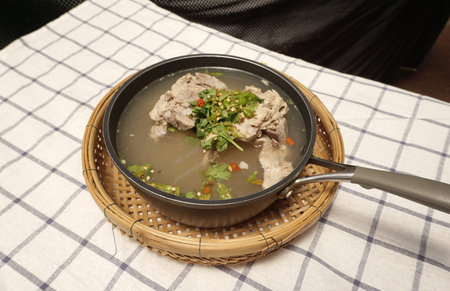 homemade spicy pork rib soup in the pot on pliad fabric background