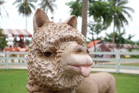 Alpaca sculpture head with farm backgroundの写真素材