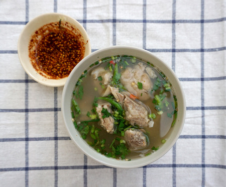 Homemade spicy pork rib soup in a bowl on plaid fabricの写真素材