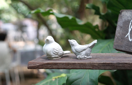 Two Birds sculpture on the timber plank with nature backgroundの写真素材