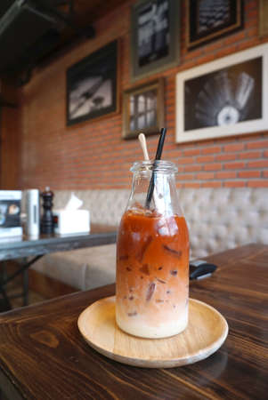 Thai ice tea with milk in the bottle with brick wall backgroundの写真素材