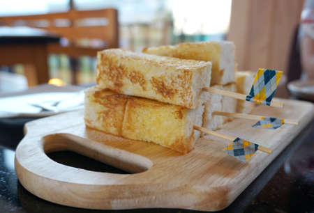 Toast stick with icing on top and serving with maple syrup sauceの写真素材