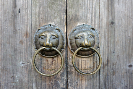 Traditional Chinese lion face door knob on rustic timber doorの写真素材