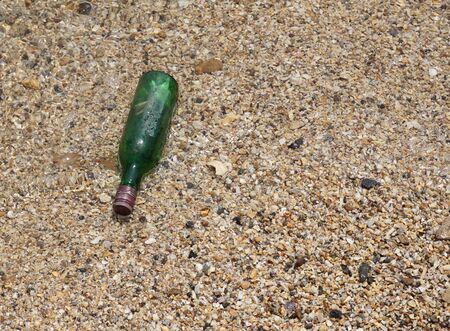 Massage in a green bottle on the beach with sand textureの写真素材