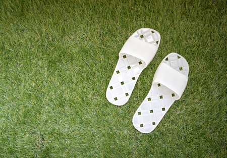 white plastic slippers on syntatic grassの写真素材