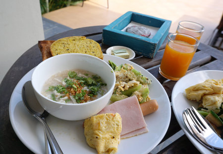 Healthy Aisan breakfast combination of Chicken boiled rice with stir fried vegetable and homemade breadの写真素材