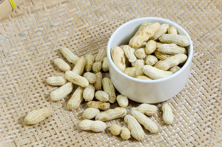 peanut with shells and white bowl on the basket