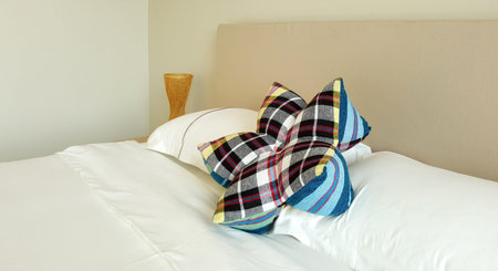 flower shape Thai local pliad pillow on white bed sheet