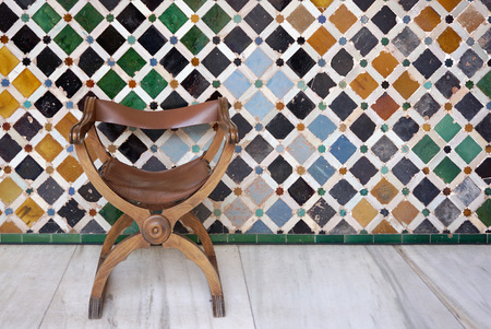 Antique timber with leather seat chair with islamic mosiac wall pattern backgroundの写真素材