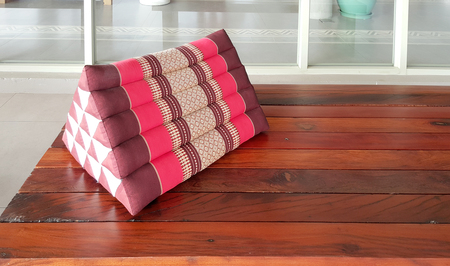 traditional Thai triangle pillow on the timber benchの写真素材