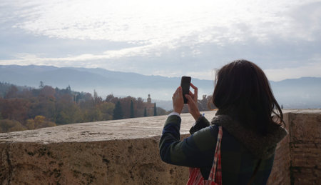 woman taking a photo with smartphone with nature background