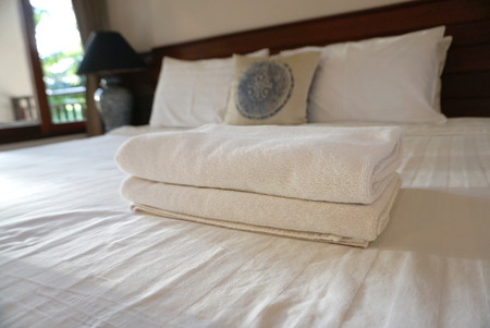White towels on white bedsheet with pillow backgroundのeditorial素材