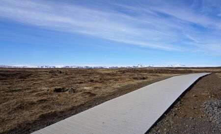 Beautiful walkway in meadow with snow mountain backgroundの写真素材