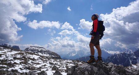 Female trekker standing on the rock with beautiful landscape background in Dolomite, Italyの写真素材