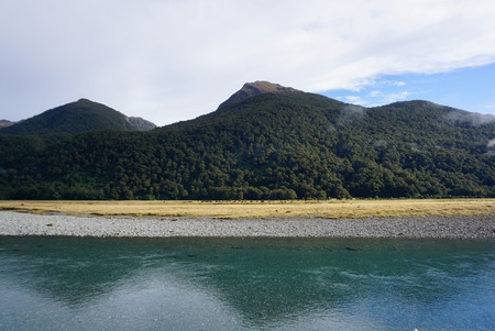 Beautiful landscape of the meadow and river along the road in New Zealand in Mayの写真素材