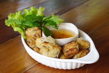 Deep fried spring rolls serving fresh cabbage and mints with plum sauceの写真素材