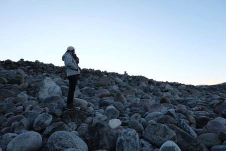 Woman traveler standing with beautiful landscape of round shape rock at Teriberka, Russia
