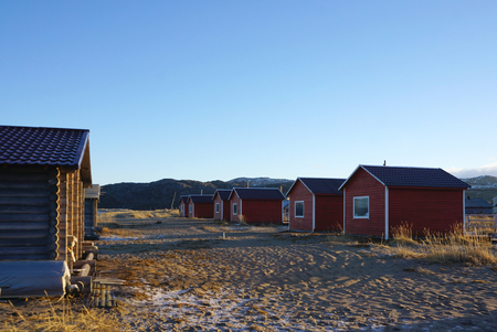 Small red houses on the Barents Sea at the arctic coast in Teriberka , Russiaの写真素材