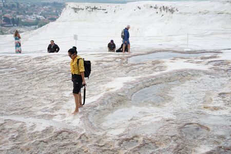 Denizli , Turkey - 16 April ,2019 : Tourist walking on white travertines terrace of Pamukkale landscape with blue thermal water  on 16 April ,2019 in Denizli , Turkeyのeditorial素材