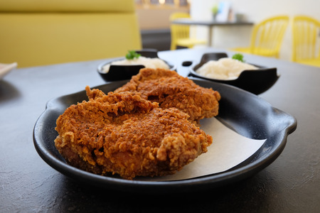 Spicy crispy fried chicken serving with sticky rice on dark surface table backgroundの写真素材