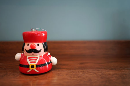 Christmas decorative small ceramic doll on timber table and blue background