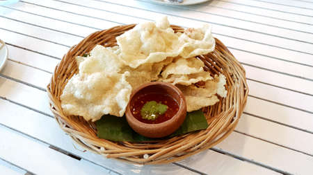Crispy Fried Fish Wonton Thai style serving with sweet and sour dipping sauce on the woven basketの写真素材