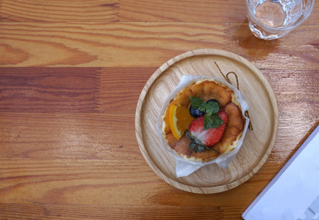 Burned cheese cake with strawberry and blueberry toppings serving on timber trey