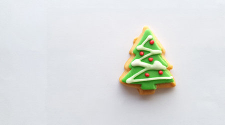 Green , red and white Christmas tree decoration on butter cookies on white background
