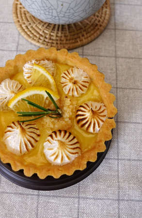 Top view of the circle shape baked lemon cheese tart on table with small plantsの写真素材