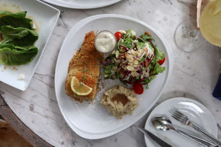 Grilled sea brass with crispy powder serving with fresh salad amd mash potato on white plateの写真素材