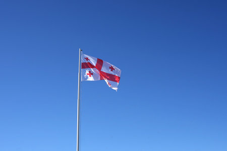 Georgian flag on the pole on the beautiful old ruin of Gori fortress on the hill of Gori town on the sunny dayのeditorial素材