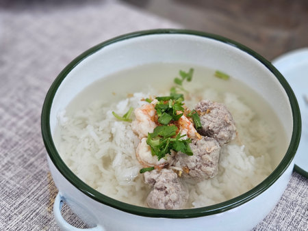 Asian style Shrimp and ground pork boiled rice with clear soup on white bowlの写真素材