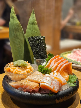 Variety of Salmon sashimi set on ice in the black bowl in Japanese restaurant.の写真素材