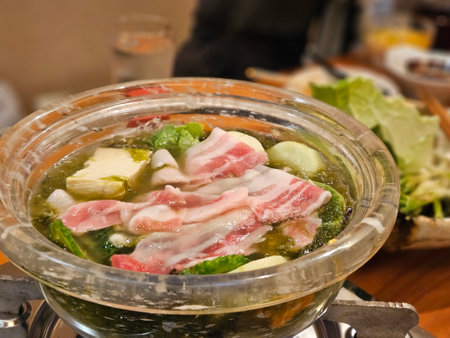 Close up of special Agu pork meat of Okinawa area for shabu shabu traditional Japan dish with a bowl of local on timber table.の写真素材