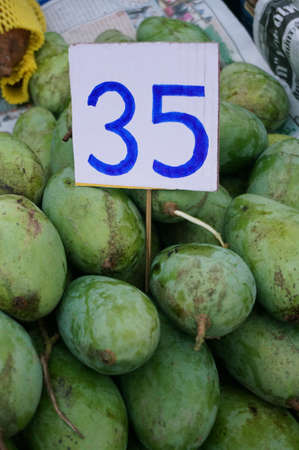 Close up of photo of very fresh green mangoes with the price for saleの写真素材