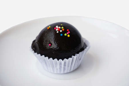 chocolate ball with topping in paper cup isolated on white background, close upの写真素材