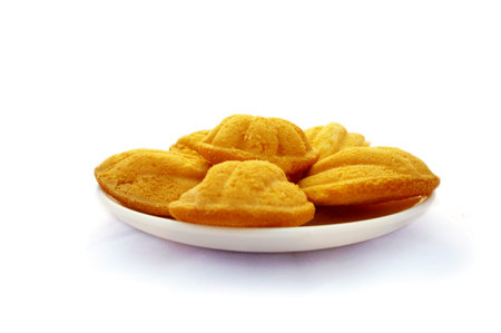 Madeleines cookies, Thai style, on white plate isolated on white backgroundの写真素材