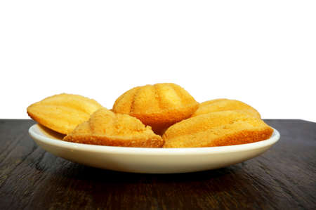Madeleines cookies, Thai style, on white plate on wooden table isolate on backgroundの写真素材