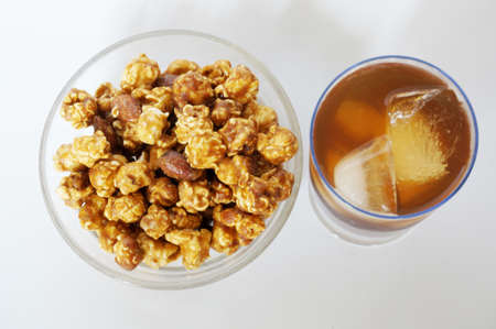 Caramel popcorn on white plate and cola on champagne glass isolated on white background, top viewの写真素材