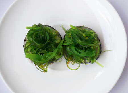 Japanese food. two pieces of seaweed sushi on white plate isolated on white background.の写真素材