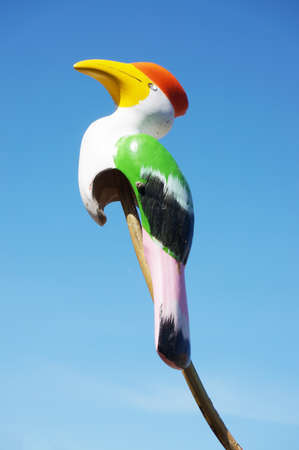 Colorful multicolor wooden carving of hornbill toy bird under the blue sky backgroundの写真素材