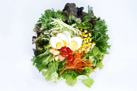 Fresh vegetables salad, corn, tomatoes, apple, cabbage, lettuce with boiled eggs, top viewの写真素材