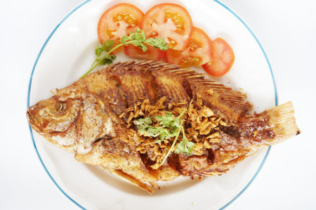 Asia - Asian eating food, Thai food, fried Nile tilapia river fish ( Oreochromis niloticus ) with...