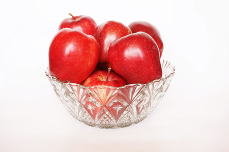 Close up of photo of very fresh red apples in crystal glass bowl isolate on white backgroundの写真素材