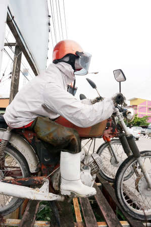 Old artificial doll of man riding motorcycle beside the road in townの写真素材