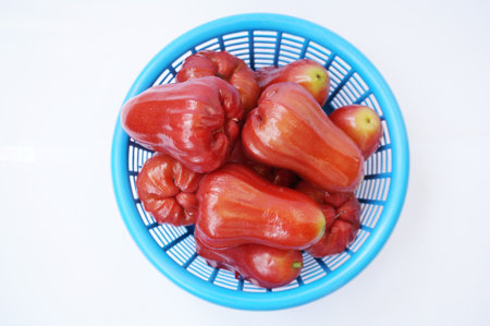 Rose apple fruits or chomphu on blue basket isolated on white background