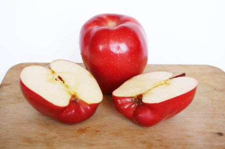 Close up of photo of very fresh red apple and sliced apples on wood cutting board isolate on white backgroundの写真素材